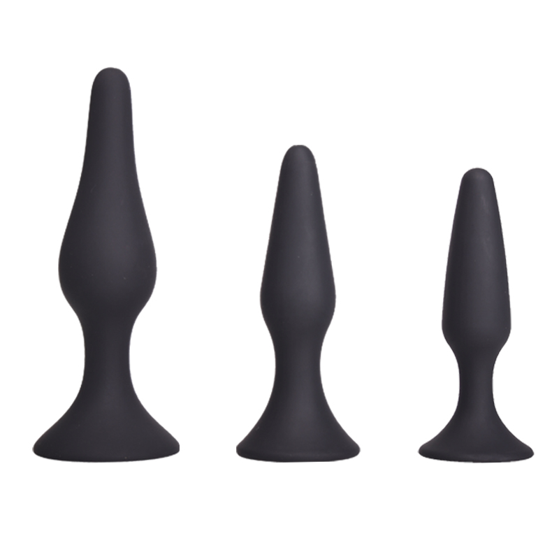 Image showing three black silicone training plugs. They are of different sizes, from small to large, arranged in ascending order from left to right. Each plug has a tapered shape and a flared base.